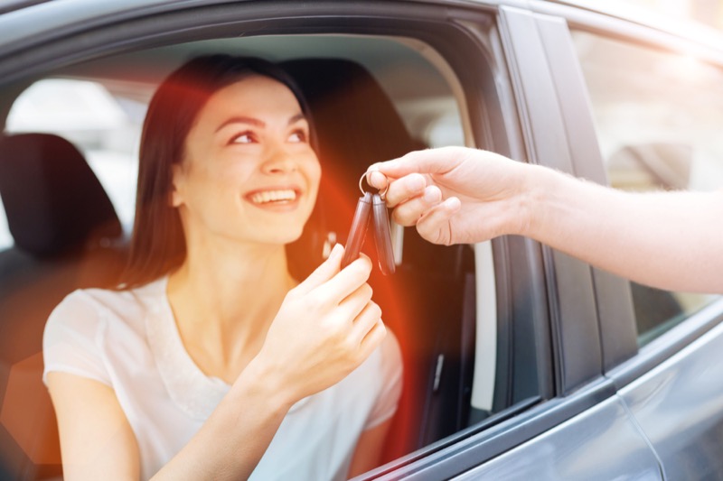 Happy charming woman receiving car keys
