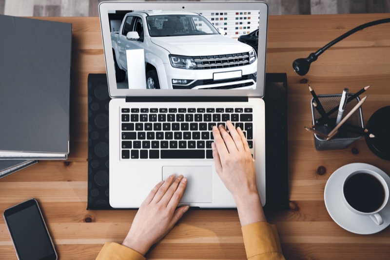 renting online. Woman choosing car using laptop, top view